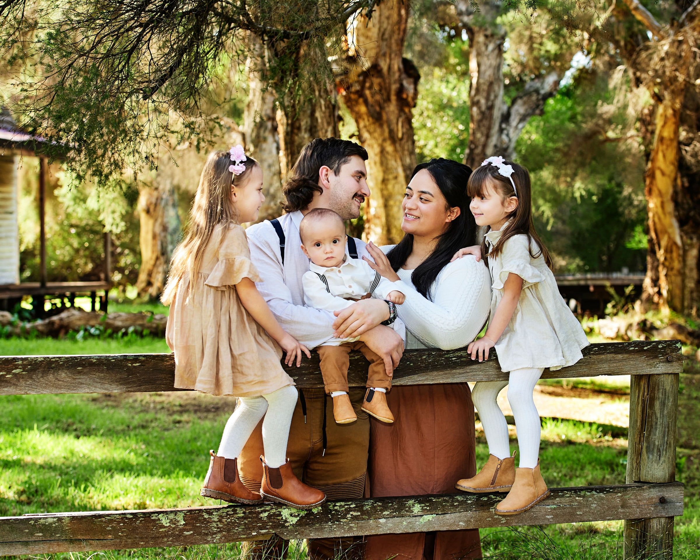 A family with their baby at the fence beside the cottage