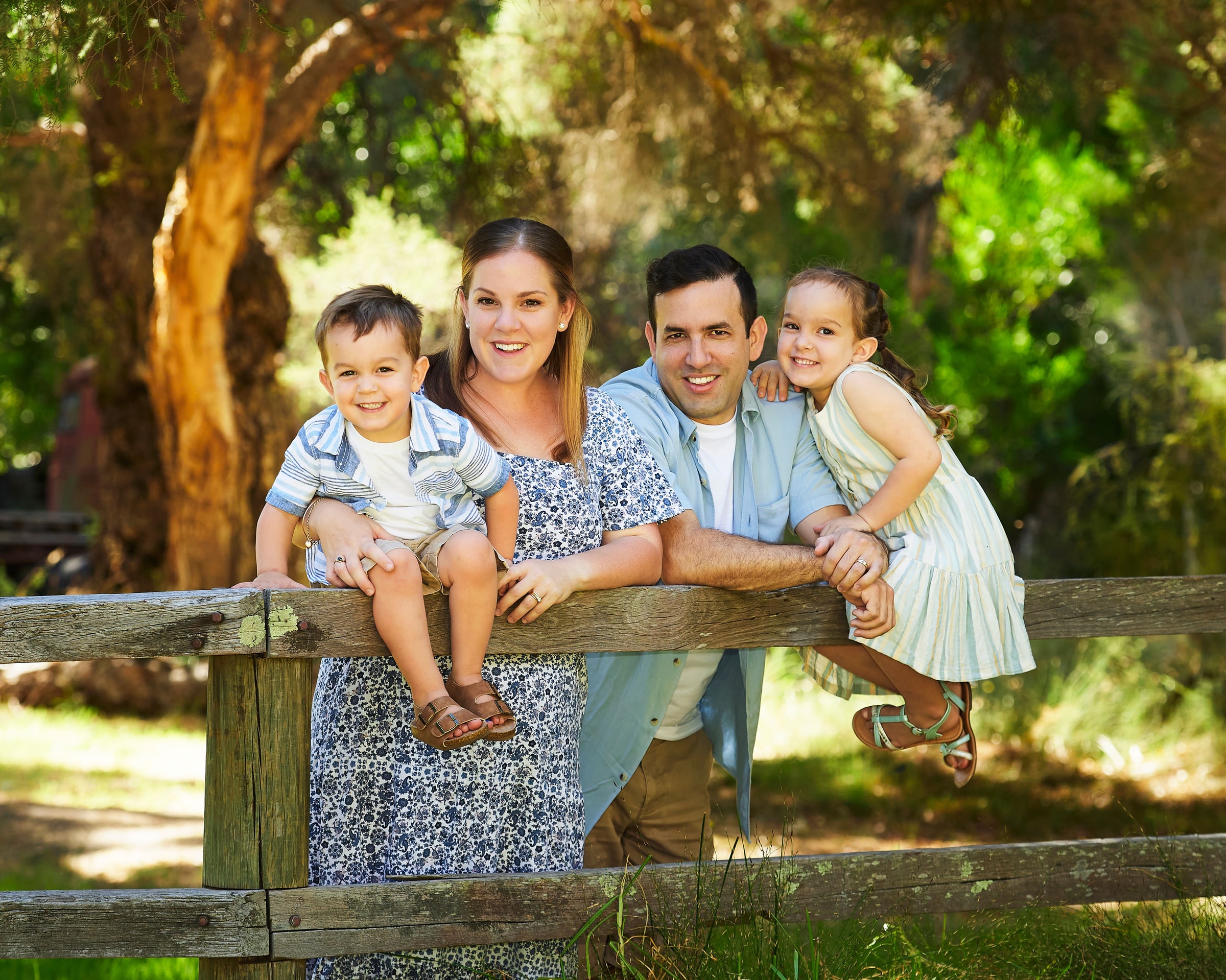 Parents and their two children leaning over the fence rail