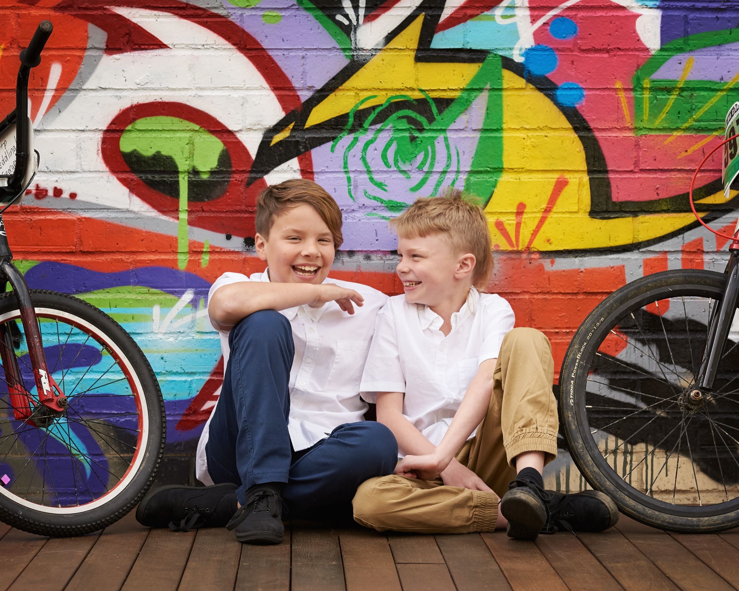 Two brothers with their bikes in front of the graffiti wall