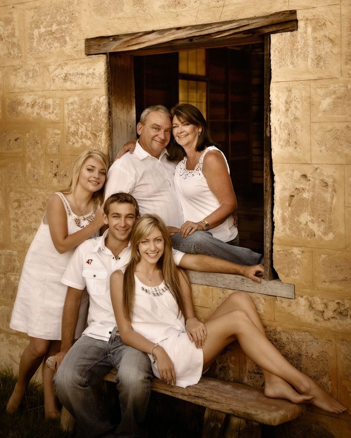 A family of five gathered around the limestone window