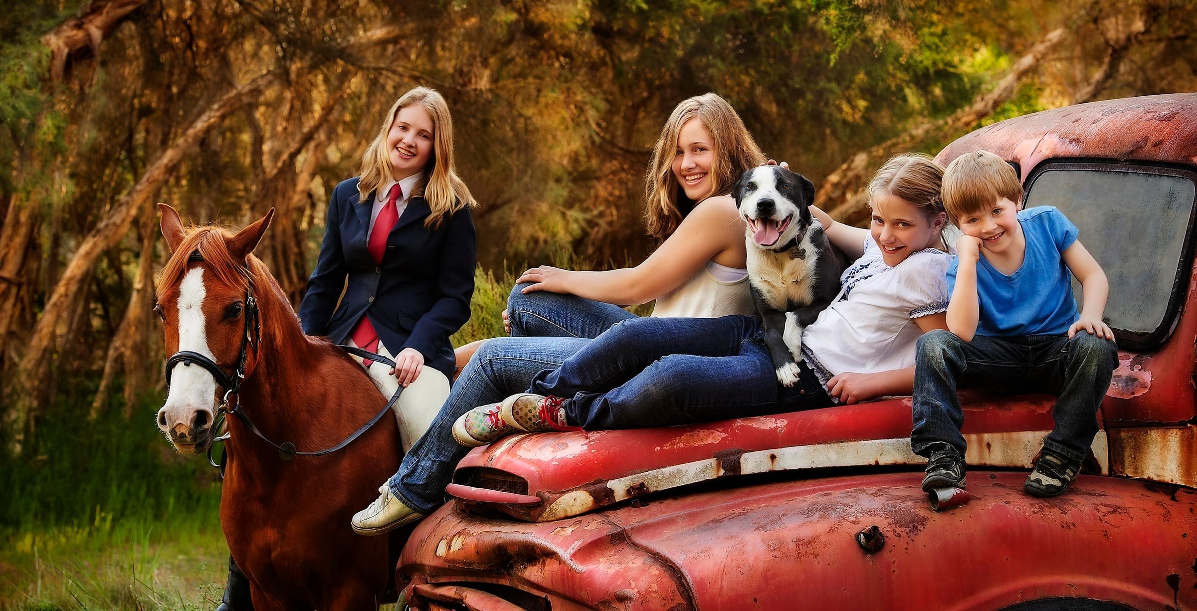 A family with their horse and dog at the red truck