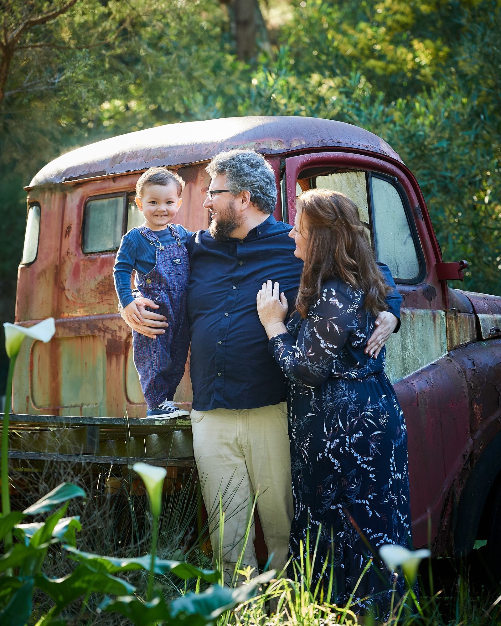 A family standing beside the vintage red truck