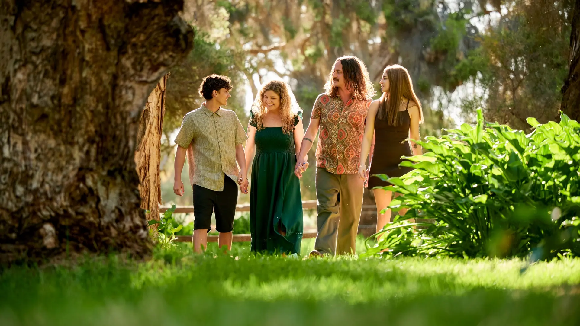 A family walking hand in hand through the bushland, a still from the Premier Studio film