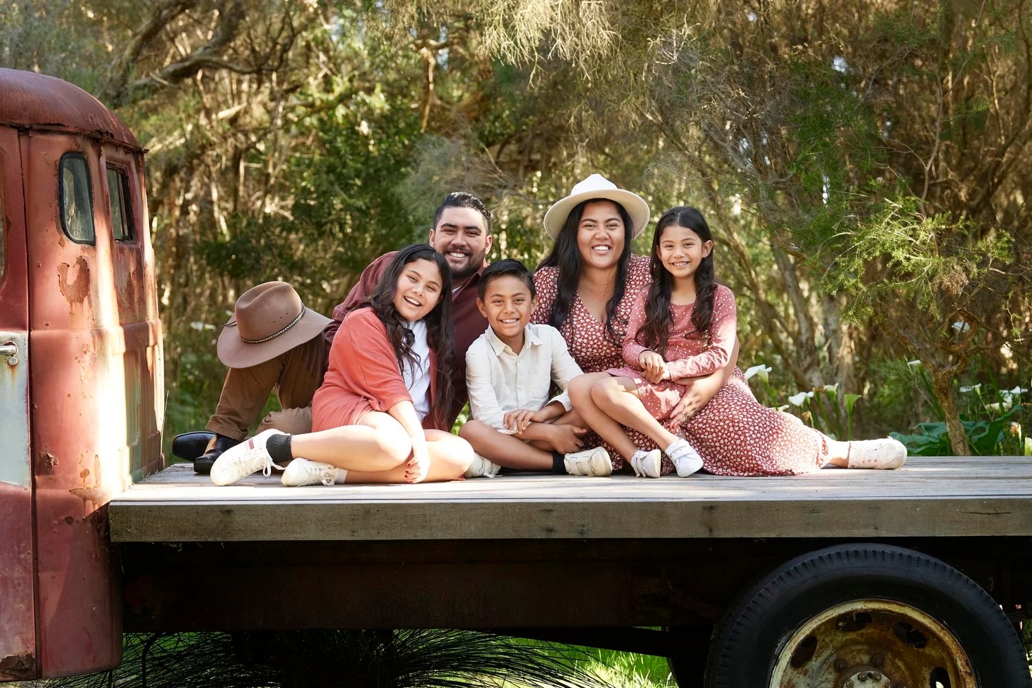 A large family photographed together on the vintage truck