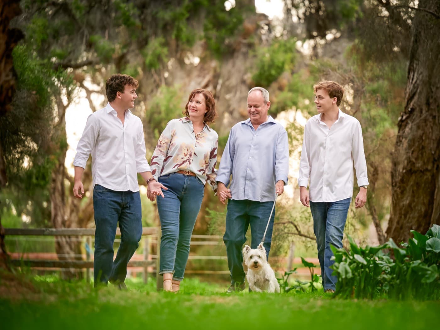A family walking together with their small white dog