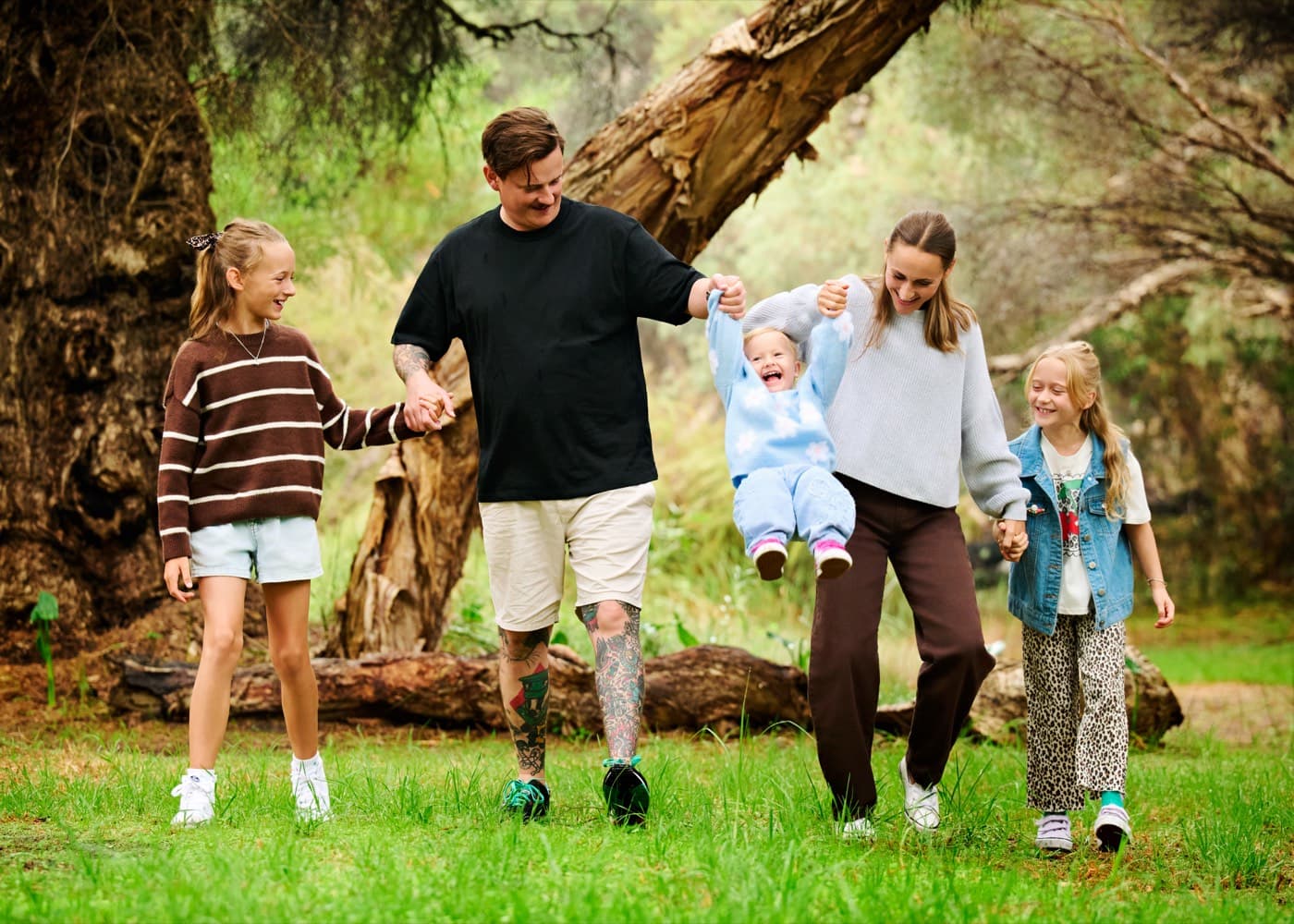 A family swinging their toddler between them as they walk