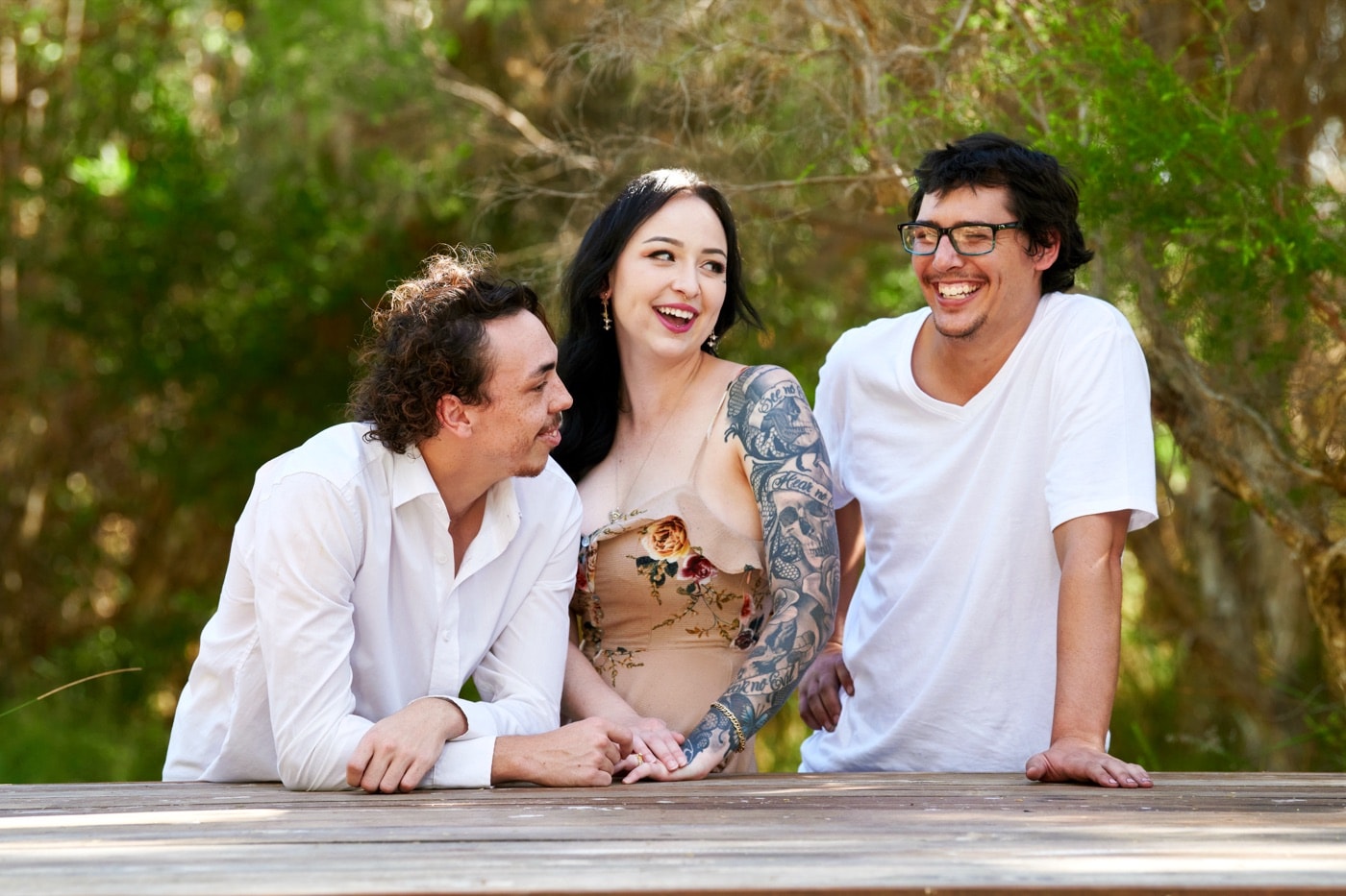 Three grown siblings leaning on the timber deck