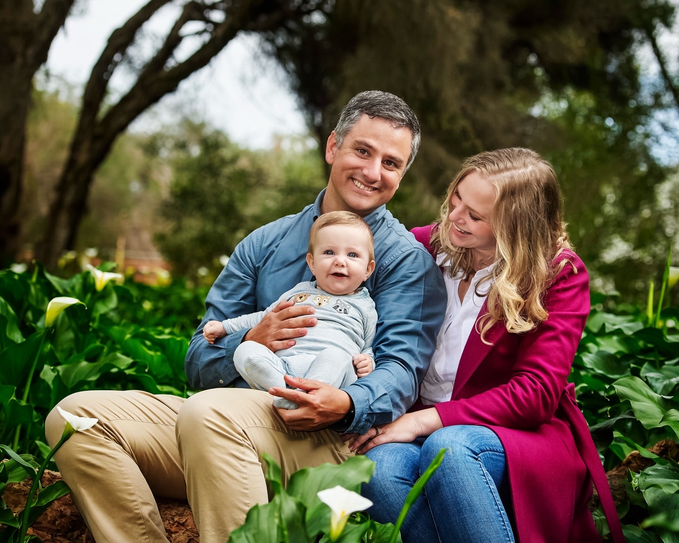 Young parents with their baby among the arum lilies