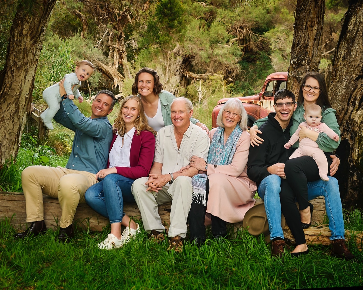 Three generations on a log bench in the bushland