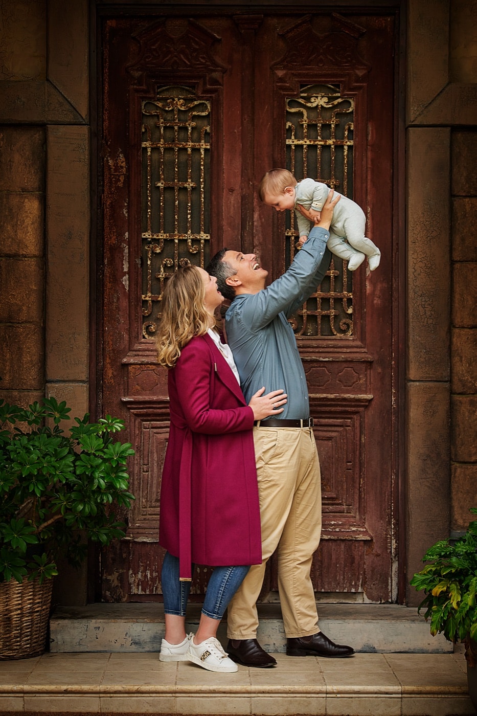 Parents lifting their baby high at the Egyptian doors