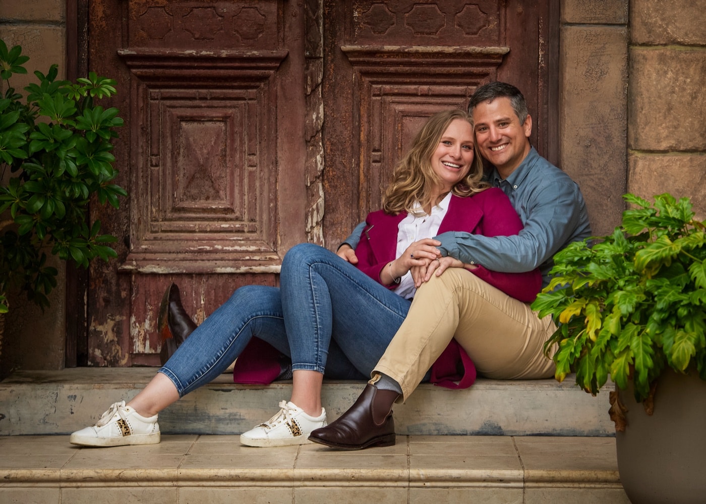 A couple sitting on the step by the carved doors