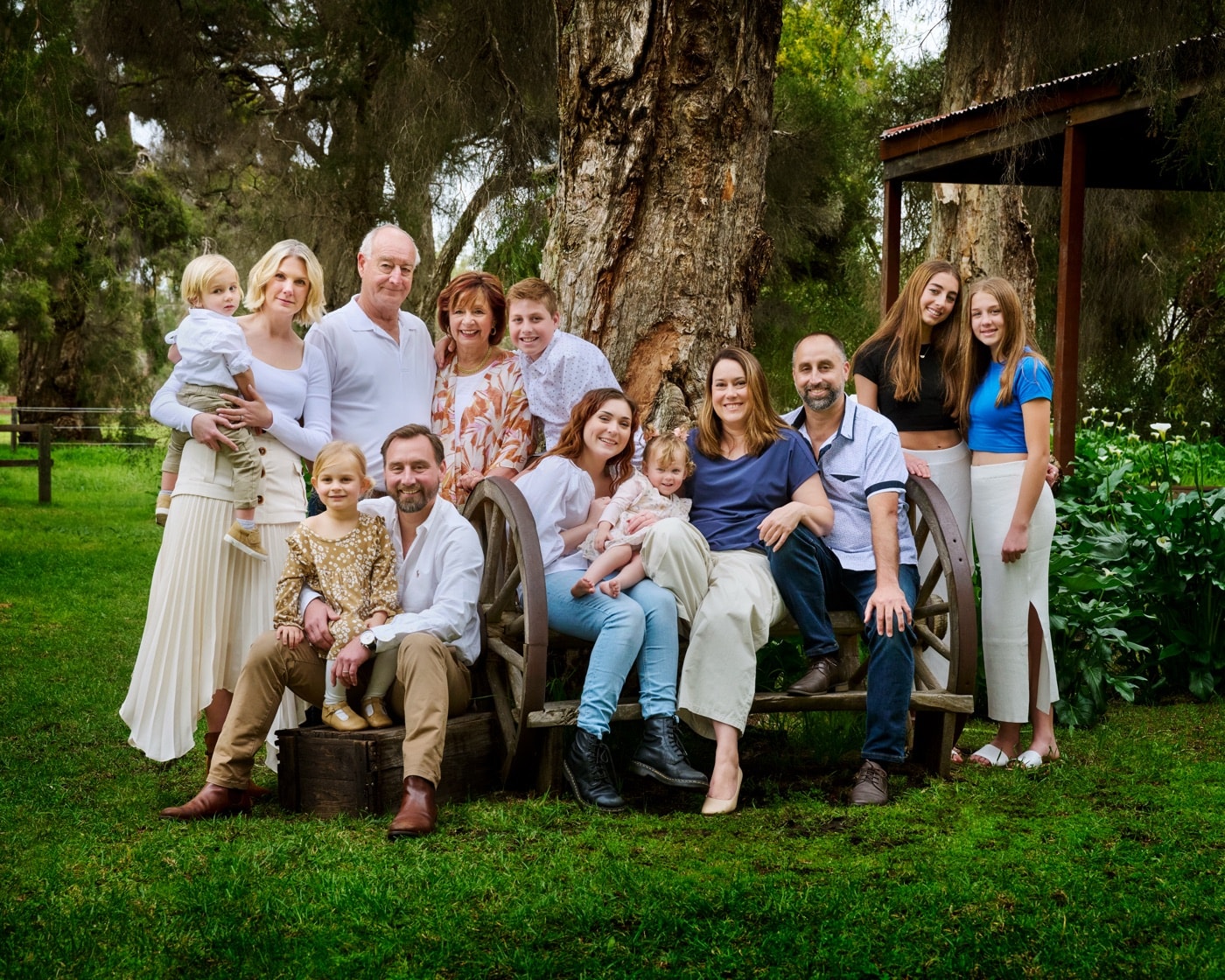 A large extended family gathered on the bench by the cottage