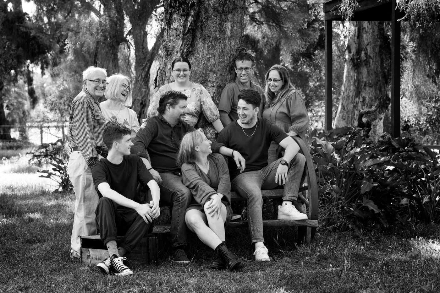 An extended family in black and white under the trees