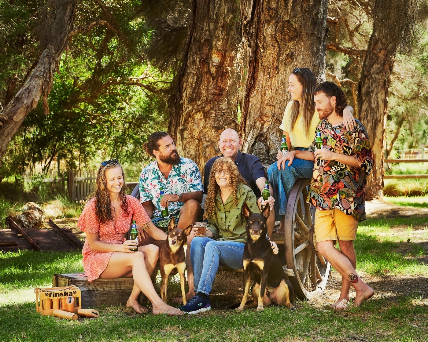 A family with their dogs by the old wagon wheel