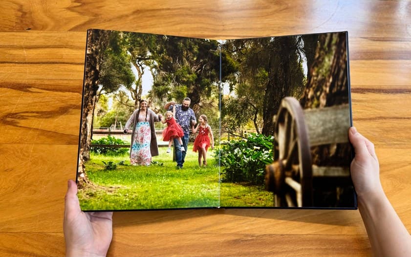 A layflat designer album open to a full-width family portrait spread
