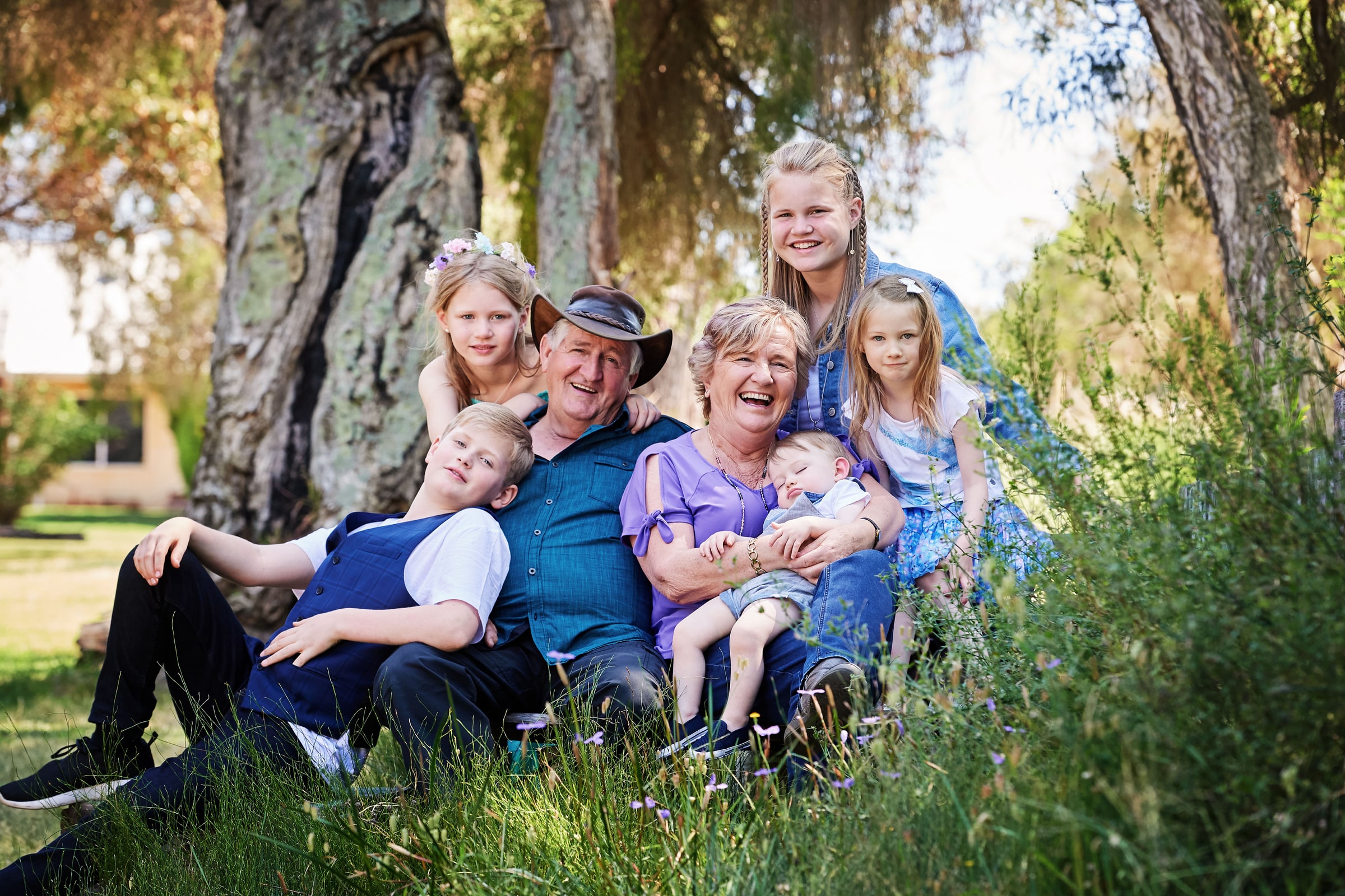 Three generations of a family sitting together in the long grass