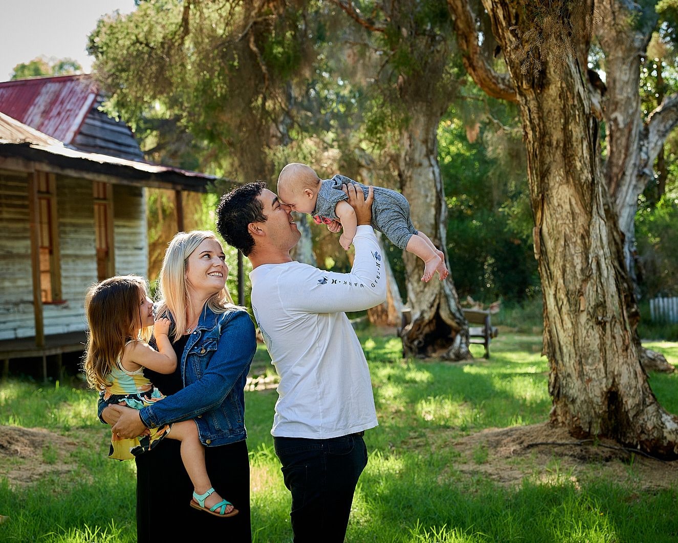 A family playing together on the lawn beside the cottage