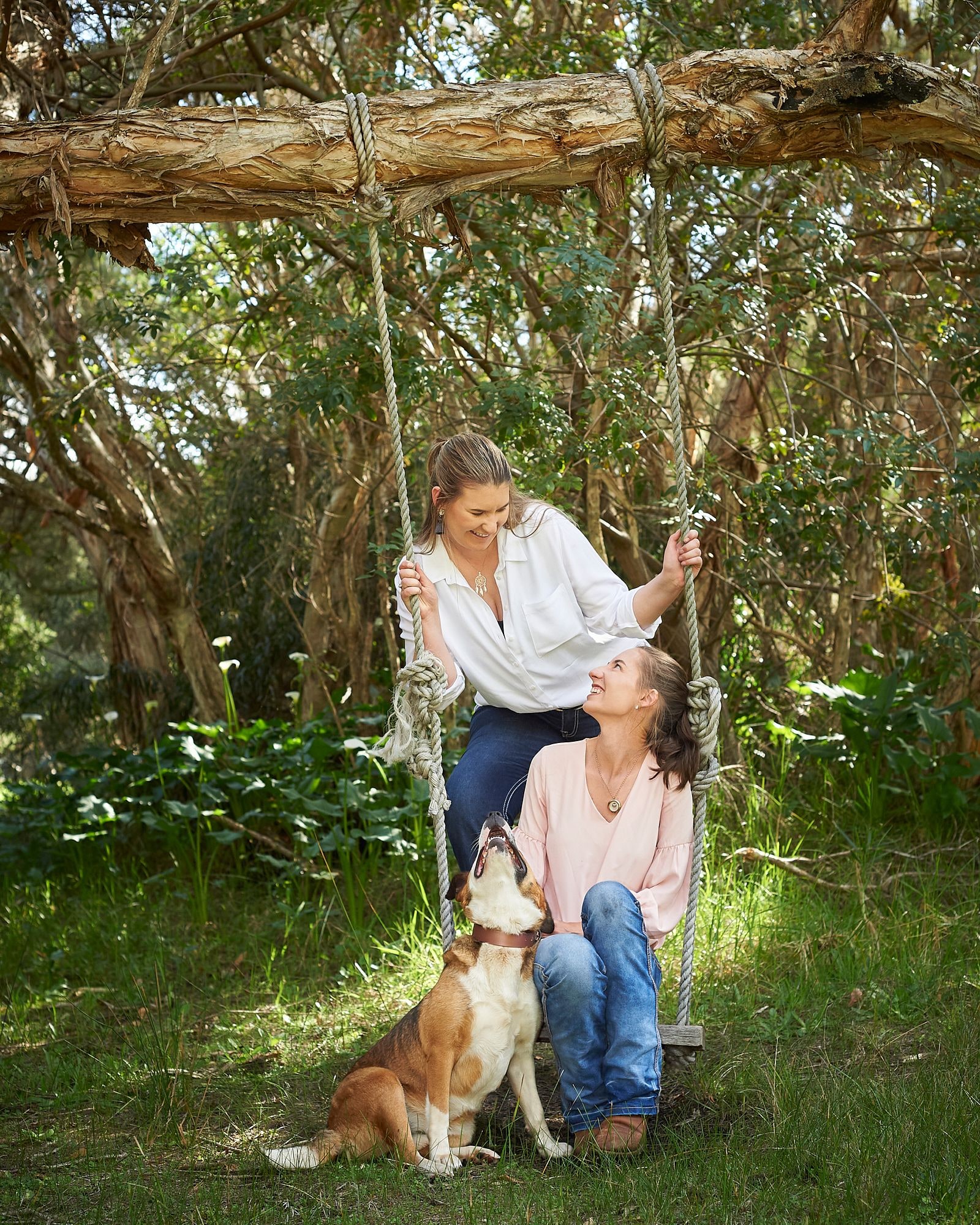 A mother and daughter at the tree swing with their dog