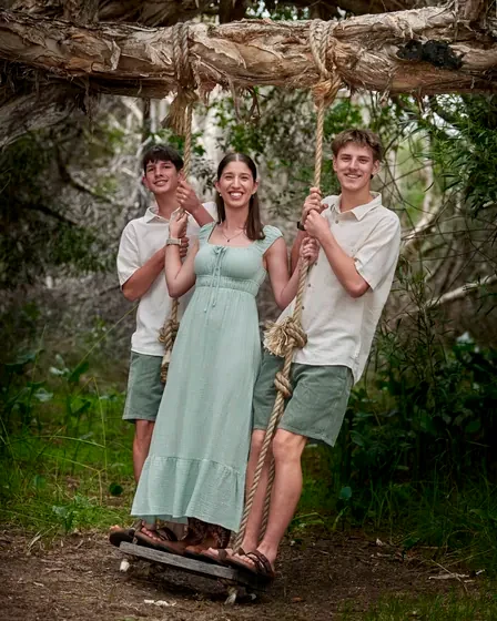 Mum in sage green with two teenage sons in cream and olive on the rope swing at Premier Studio