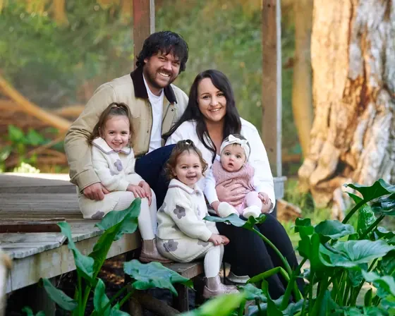 Family of five in cream knits and dusty pink seated among the arum lilies at Premier Studio