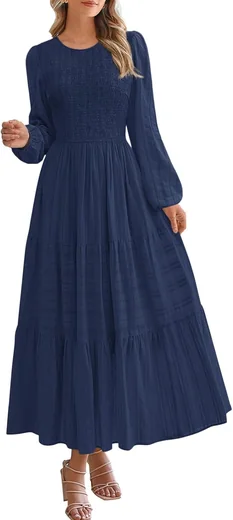 Woman in a navy smocked long-sleeve tiered maxi dress, product photo